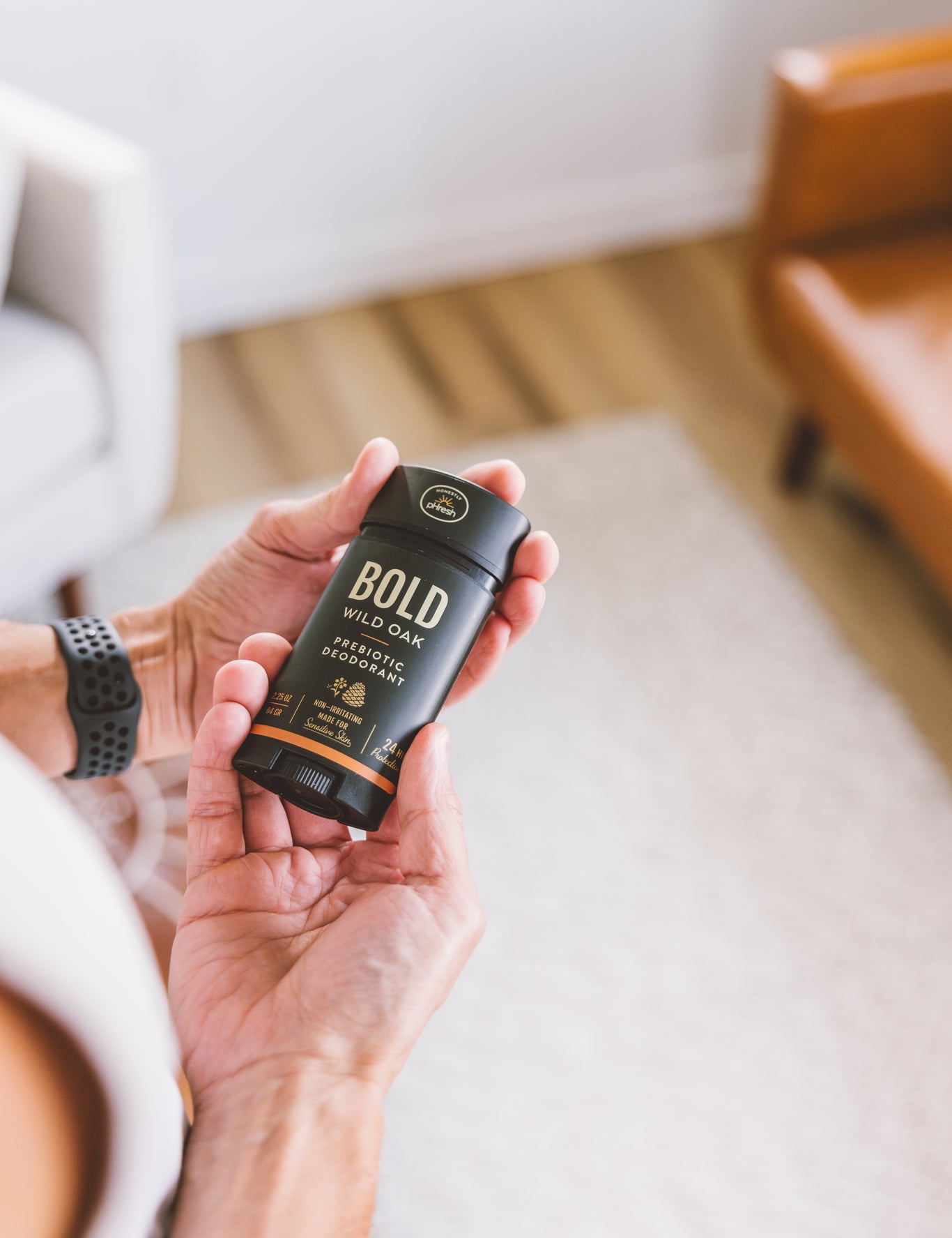 A person holding Bold Wild Oak prebiotic deodorant stick made with a mineral magnesium blend for gentle odor support.