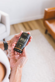 A person holding Bold Wild Oak prebiotic deodorant stick made with a mineral magnesium blend for gentle odor support.