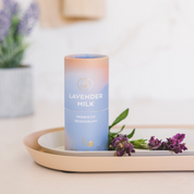 Natural magnesium-infused deodorant stick in Lavender Milk scent on a wooden tray with fresh lavender.